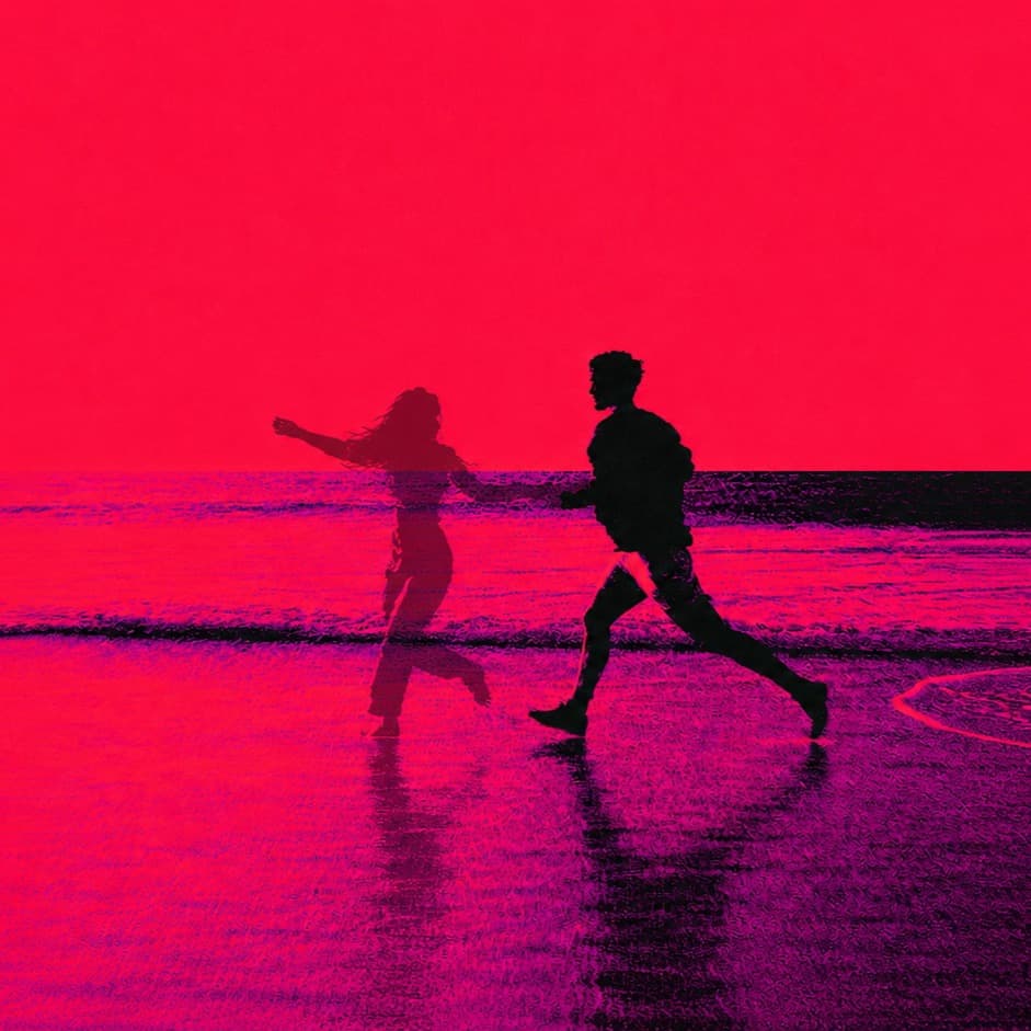 Two figures in pink-duotone silhouette parting at the water's edge on a beach
